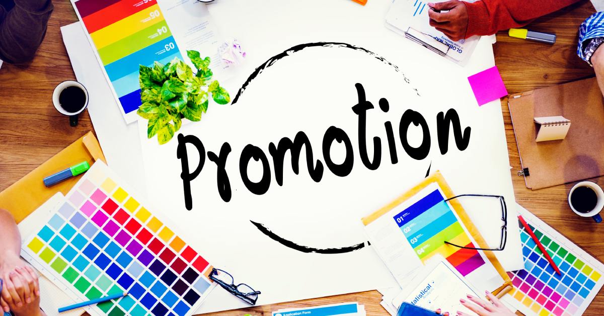 A white poster with the word "promotion" written on it lays across a desk surrounded by color swatches.